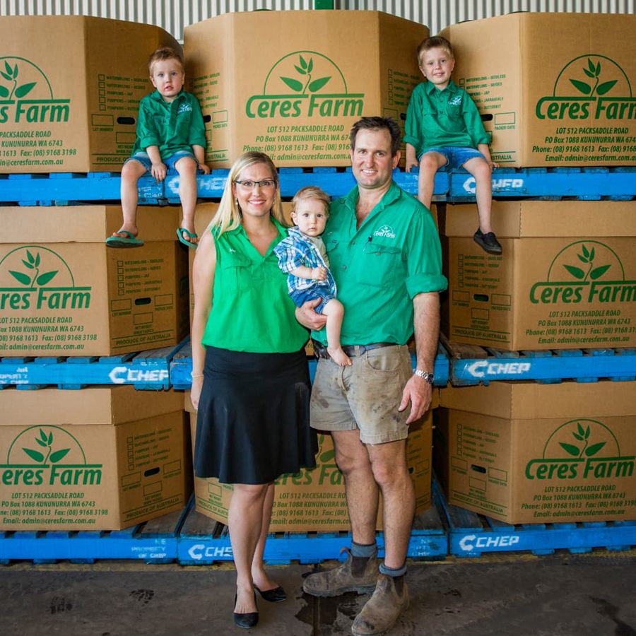 Matthew and Melanie Gray with their three young sons in front of pallets of Ceres Farm cartons