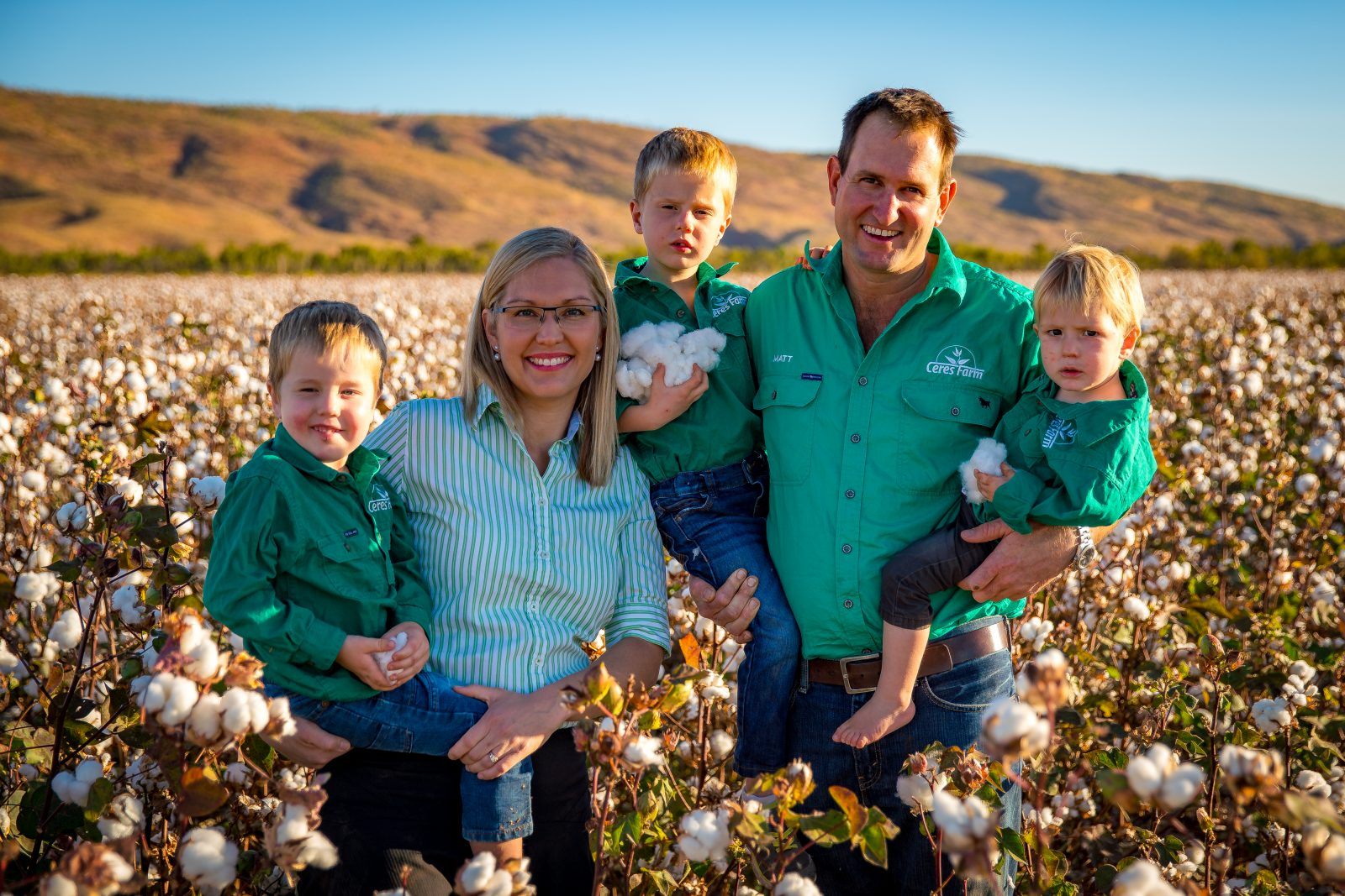 Matthew and Melanie Gray with their three sons standing in a cotton crop ready for picking, with the Kimberley ranges behind