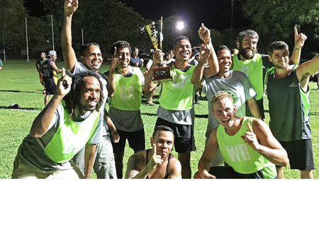 The Ceres Farm soccer team celebrating with the Ord Valley Cup trophy at night on Kununurra Town Oval