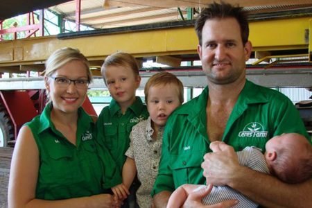 Matthew and Melanie Gray with their three young children, including a newborn, in the farm shed