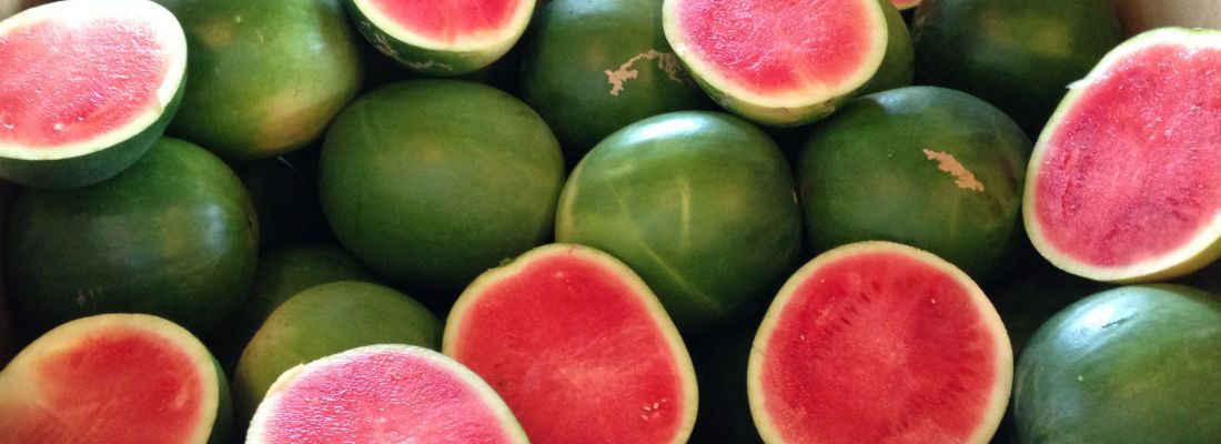 Whole and halved seedless watermelons